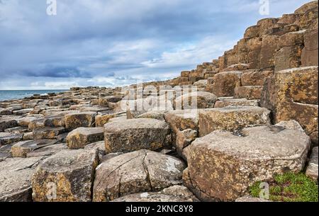 atlantic coastline with Volcanic hexagonal basalt columns of Giant`s Causeway at sunset in Northern Ireland Stock Photo